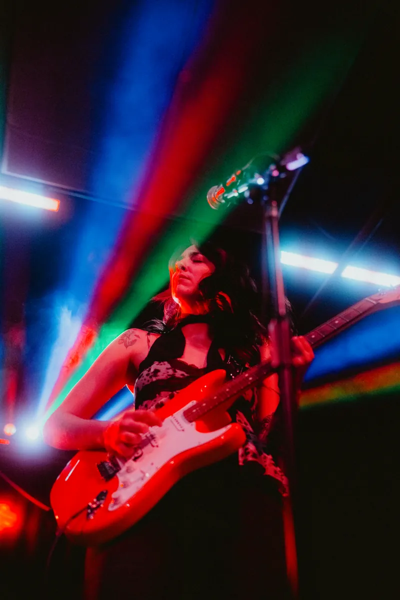 Lilah mid-solo under rainbow beams