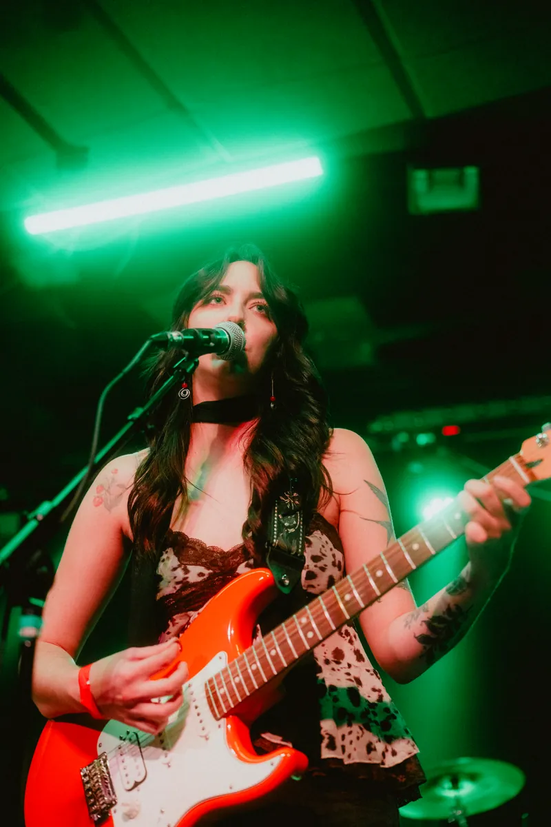 Lilah singing under green light
