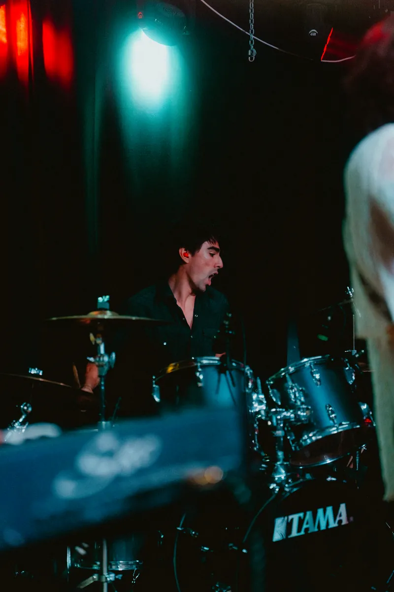 Mateo on drums under teal light