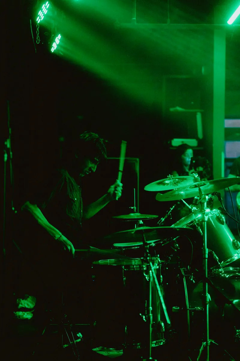 Mateo on drums under green beams